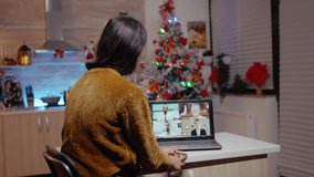 Woman using video call for work meeting on christmas eve while frustrated man waiting to celebrate holiday festivity. Person working on business instead of enjoying seasonal celebration