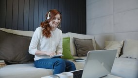 Happy Girl Student Enjoy Success Looks At Laptop At Home Office. Joyful Young Woman Reading Good News On Laptop. Surprised Lady Celebrates Online Success Sits On Sofa At Home