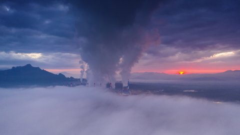 Hyper lapse, Beautiful Landscape in the morning time with fog and background Mae moh coal power plant Lampang, Thailand. The industrial white steam from cooling tower pipes, concept environment.