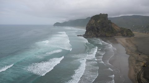 View of the famous iconic Lion Rock formation in Piha, New Zealand on cloudy overcast day in 4K.