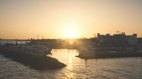 Ayia Napa, Cyprus - May 16, 2021: Drone flight over sunset city port pier. Marina parking for cruise ships and yachts. Summer sunset seascape coast. Vacation, travel, holidays, open border.