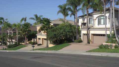 Pan of residential street with luxury Southern California homes. Video taken in Carlsbad, CA USA on September 10, 2021.