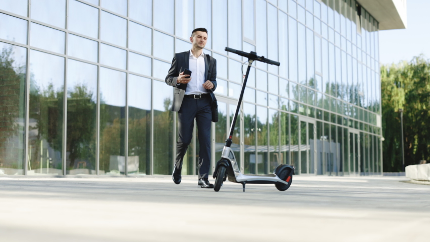 Tourist taking e-scooter or bicycle. Phone application for rental scooter. Ecological city transport. Businessman rents electric scooter using mobile phone app. Man take electric kick scooter