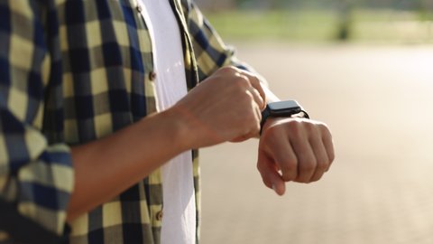 Smart watch. Smart watch on a man's hand outdoor. Man's hand touching a smart watch. Close - up shot of male's hand uses of wearable smart watch at outdoor.