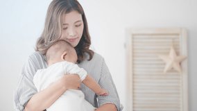 Image of a mother holding a baby at home - Powered by Shutterstock - Get 15% off with code: PIKWIZARD15