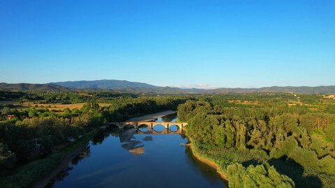 Aerial wiev drone bridge built in 1240 painted on Leonardo Da Vinci Mona Lisa. Situated in the middle of Tuscany surrounded by trees above Arno river. Landscape, Village, Natural reserve, flight wiev.