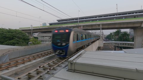 Jakarta, Indonesia - September 10, 2021: Mass Rapid Transit electric train is speeding across the railroad tracks in the afternoon at the Asean MRT railway station. Handheld, flat color profile