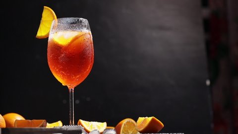 Aperol spritz with cocktail spoon. Cocktail aperol spritz with orange slices, ice and mint. Camera movement around the summer cocktail glass