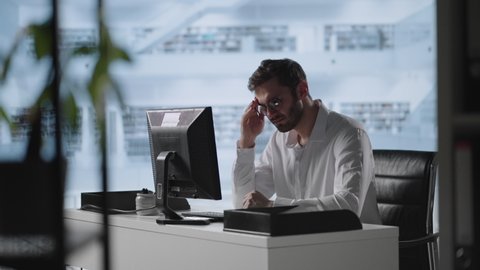 Exhausted man taking off glasses feeling eye strain from computer. Stressed overworked businessman taking off glasses tired from computer.