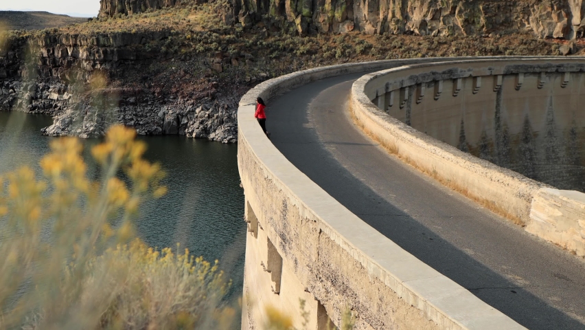Asian woman hiking near the historic 100 year old Salmon Falls Dam in Southern Idaho