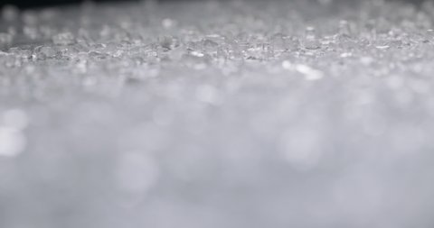 Close up shot of surface covered with clear white salt granules. Salt crystals reflecting light. Macro shot of cosmetic bath salt 4k footage