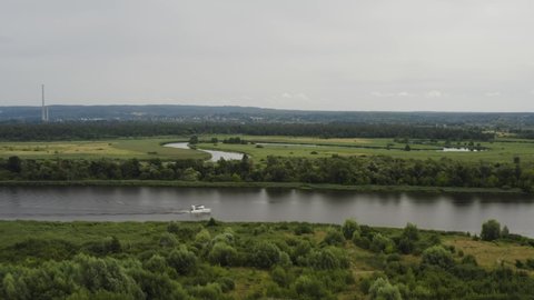 Dinghy Boat Sailing Across The River Through Green Fields At The Countryside In Poland. aerial drone