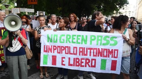 Milan, Italy - September 11, 2021: people sit-in and chant in protest during a 'no health pass' demonstration