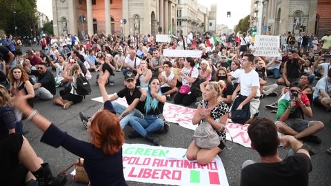 Milan, Italy - September 11, 2021: people sit-in and chant in protest during a 'no health pass' demonstration