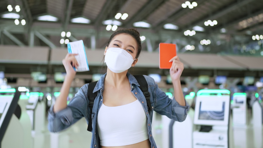 happiness smiling asian adult female wear face mask hand gesture showing passport and blank screen smartphone at aitport terminal,asian female ready to travel after lockdown ia over at airport Royalty-Free Stock Footage #1079009114