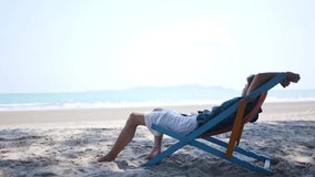 Young Asian man resting on sun bed by the sea. Handsome male in casual clothing napping on beach chair relax and enjoy outdoor lifestyle at tropical island sand beach in summer holiday travel vacation - Powered by Shutterstock - Get 15% off with code: PIKWIZARD15