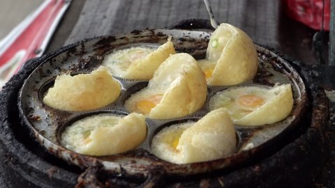 The process of making quail egg mini martabak. one of the street food in Indonesia. This snack consists of flour dough, sliced ​​scallions. Cooked in a frying pan with a small round pattern.
