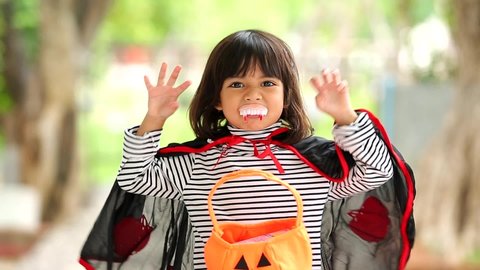 Halloween, holiday and childhood concept. Little kids southeast asian on halloween dressed in a witch costume. funny kids in carnival costumes outdoors.