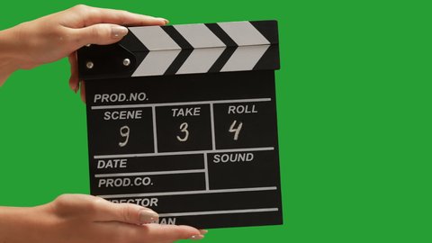 Human hands are using a clapperboard isolated on green screen. Beginning of scene in film or television production. Concept of cinematography or movie and film crew or video. Chroma key.