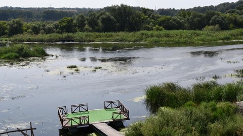 Time lapse water sport of inflated boats rafting by river Southern Bug with shores overgrown by reeds and bulrush. Landscape of Bug Gard islands in Ukraine. Plate with text - do not jump into water