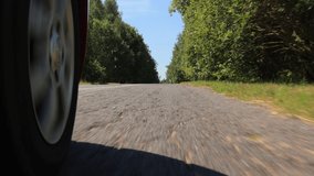 Video shooting in motion, driving a red car over the road along the asphalt at speed, view from the wheel.