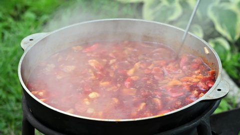 Hungarian traditional bograch. Making stew on open fire. german comfort food. Traditional Hungarian Goulash in cauldron. Transcarpathian dish. Soup with meat and paprika. Eintopf, chili con carne.