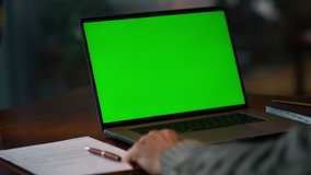 Green screen laptop computer closeup. Unknown senior man having video call at chroma key laptop screen at home. Unrecognizable old man making conference at mockup laptop