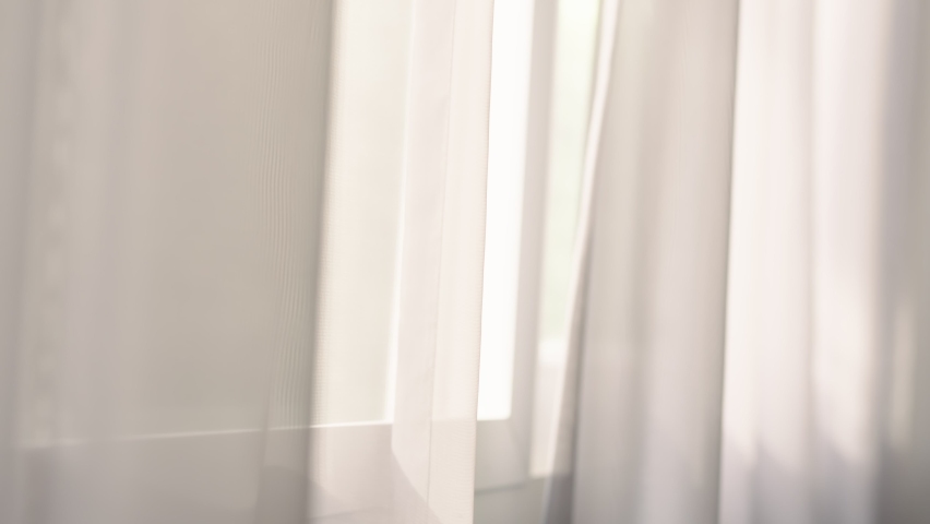 Transparent curtain moved by the wind on the window with sunlight. Royalty-Free Stock Footage #1079057576