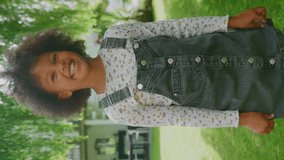 Vertical video portrait of smiling young girl with attitude standing in garden at home- shot in slow motion