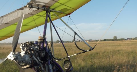 Gliding, training flights. The hang glider is on the field airfield. Shooting with hands (hand-helding) Siberia.