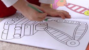 Close-up view 4k video footage of little child coloring special black and white pictures in coloring book using colorful bright pencils