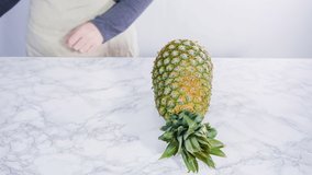 Time lapse. Flat lay. Cleaning and cutting a pineapple into the small pieces.