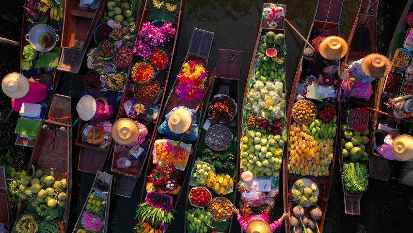Top view from drone of famous and unique floating market at Damnoen Saduak. Plenty of fresh fruits, vegetables, flowers and street food available to buy.  | Shutterstock HD Video #1079069597