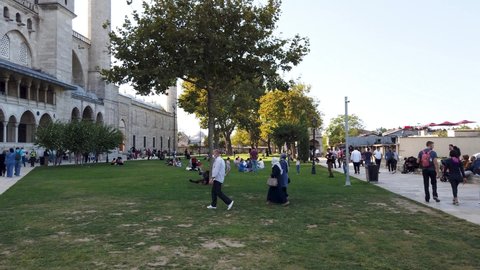 Istanbul, Turkey - September 2021: People resting in the grass area of Suleymaniye Mosque. Suleymaniye Mosque is a popular touristic spot of Istanbul