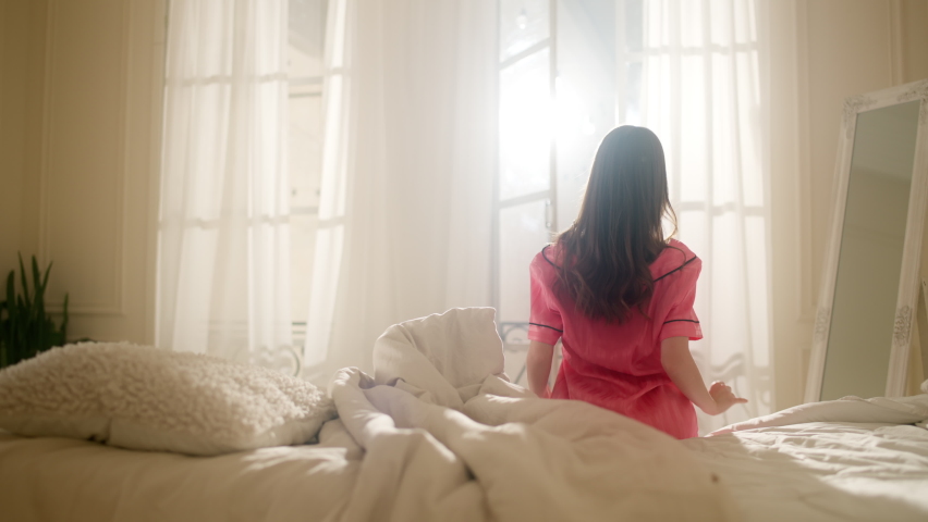 Morning shot of a girl in bed. Sun fills the room with sunlight through the window