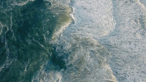 European sea destination with sunshine reflecting on foamy waves. Aerial view of stormy bluish ocean with high tides. High quality 4k footage