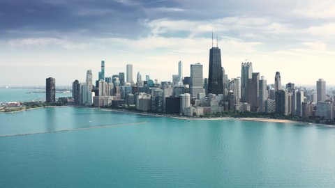 Amazing clear and vibrant blue waters of Michigan lake in Illinois with breathtaking Chicago downtown cityscape on background. Cinematic aerial Chicago coastline on sunny summer day with copy space