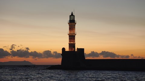 Sunset looking at an old Venetian era lighthouse in the ancient port of Chania, Crete