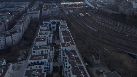 Aerial view of a passenger train passing by trees in Berlin, Germany surrounded by residential house during an early morning
