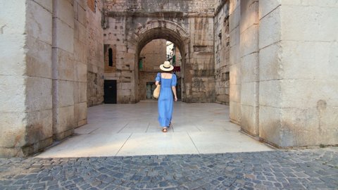 Young girl in a blue dress walking on the street in the city. Split, Croatia