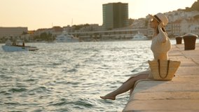 Happy woman with bare feet on the pier in summer. Split, Croatia