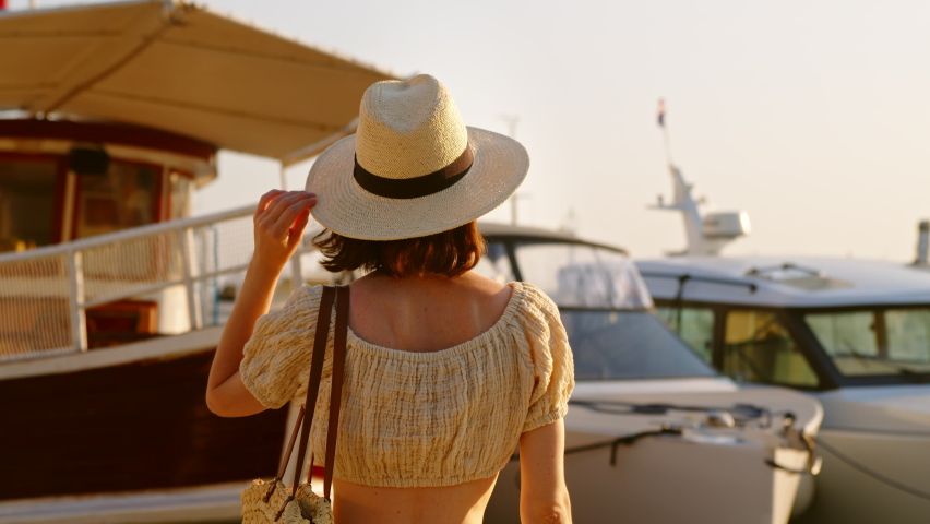 Pretty girl in hat looking at ships. Split, Croatia