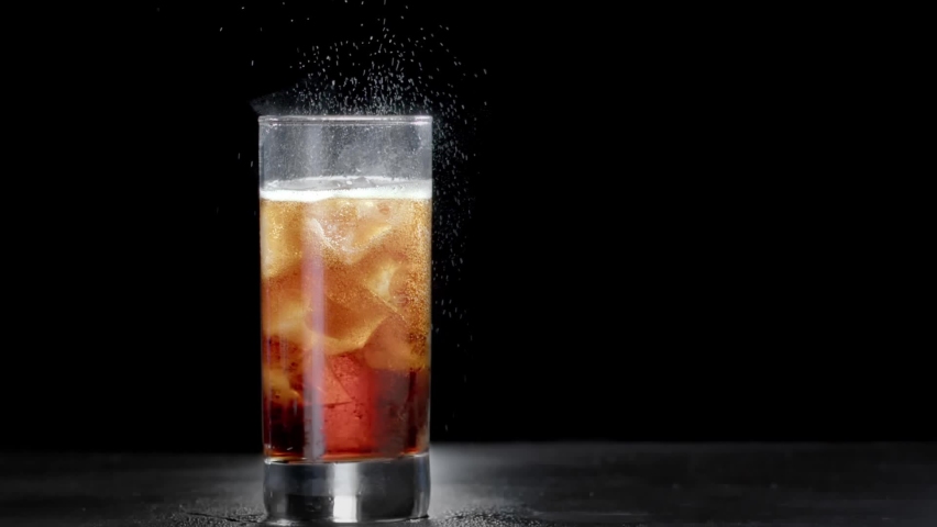 Cola with bubbles and ice cubes close-up. Cola with Ice and bubbles in glass. Soda closeup. Food isolated background. Glass of Cola fizzy drink over black background b-roll. Slow motion.  Royalty-Free Stock Footage #1079113967