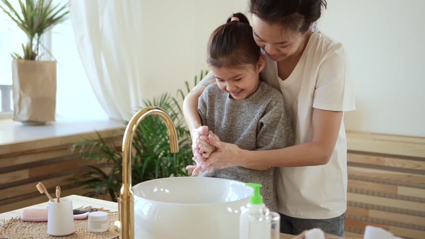 Niño pequeño lavándose las manos con dispensador de jabón en un recipiente  blanco de maqueta de cocina