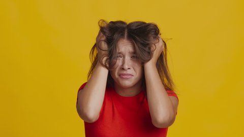 Panic Attack. Anxious Woman Posing Expressing Emotion Of Fear And Anxiety Panicking Standing On Yellow Studio Background. Negative Emotions And Mental Health Concept. Slowmo