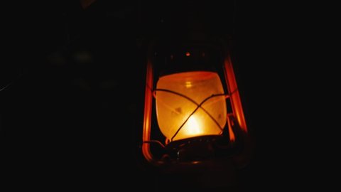 A kerosene lamp slowly swings in front of the camera in total darkness. Halloween Concept