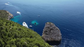 Aerial drone video of iconic Ortholithos and azure caves with deep turquoise sea where submarine Papanikolis was hiding during world war II, Paxos island, Ionian, Greece