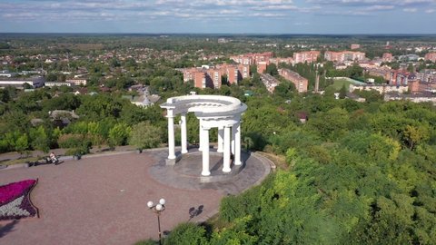Poltava, Ukraine - 13 august 2021: White rotunda or Rotunda of friendship among peoples in Poltava city, Ukrainian landmark. Aerial view with cityscape