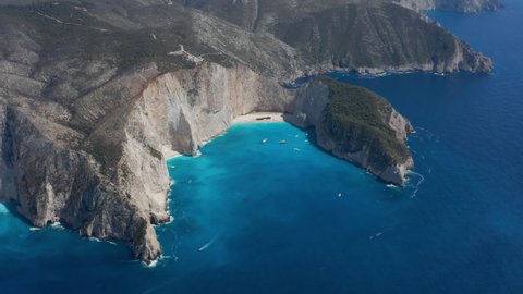 Rusty Remains Of An Old Shipwreck On Sandy Cover Surrounded By Limestone Cliffs. Navagio Beach In Zakynthos, Greece. aerial