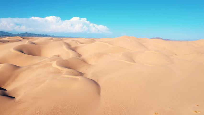Imperial sand dunes near Yuma, Arizona. Aerial with blue sky and puffy white clouds.